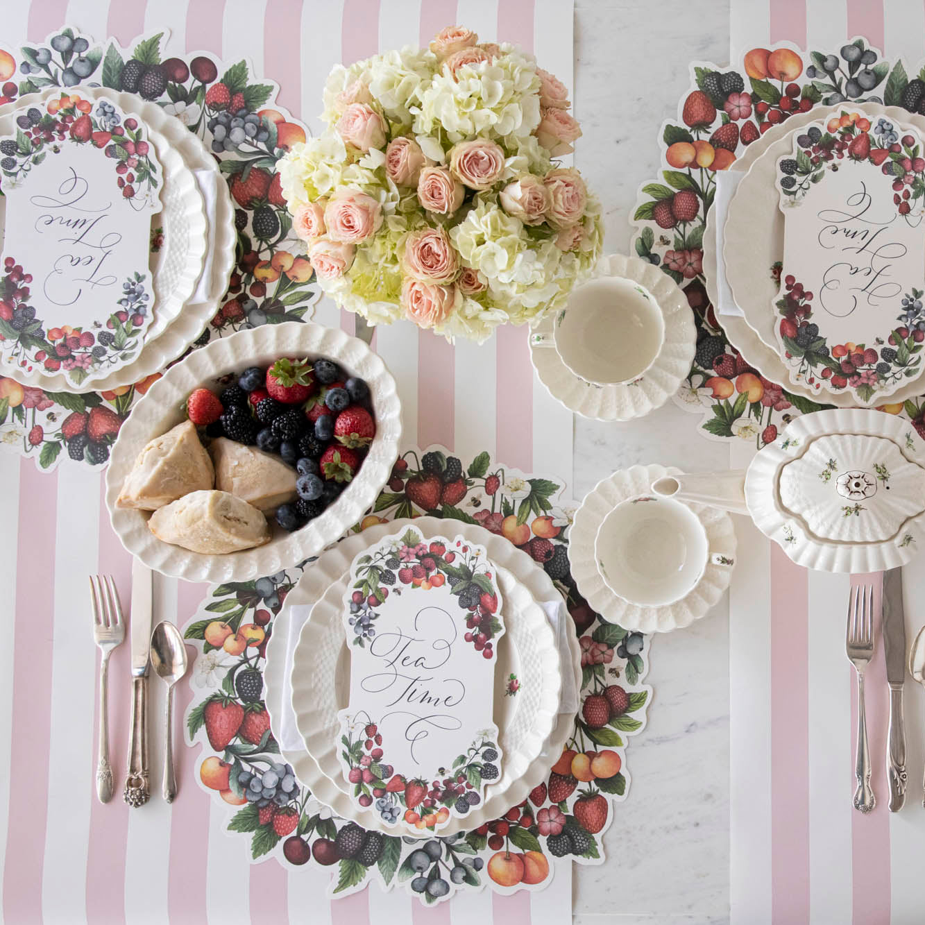 Top-down view of an elegant summertime table setting for four featuring Berry Bramble Table Cards resting on each plate.