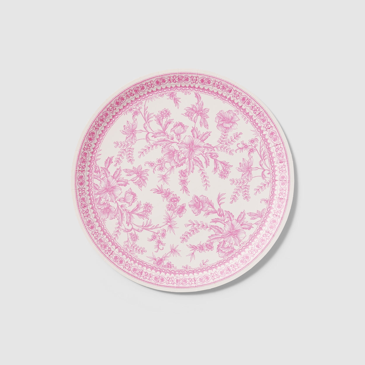 A table set with Pink French Toile Paper Party Dinnerware plates from Coterie Party Supplies featuring floral toile dinnerware patterns that evoke the charm of the French countryside, complemented by silverware.