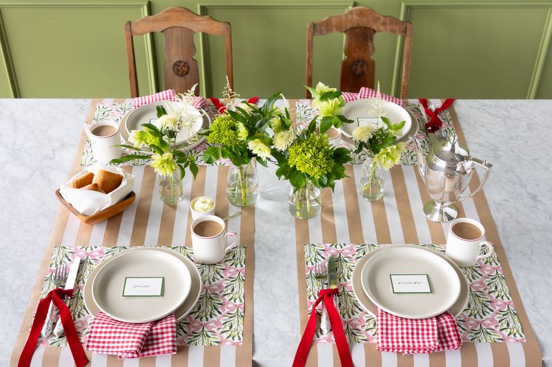 A holiday tablescape featuring mistletoe placemats.