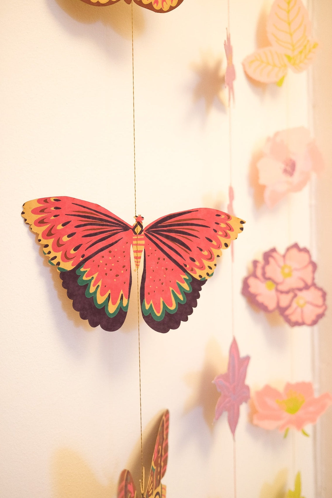 Colorful butterfly decoration on a light background with flowers.