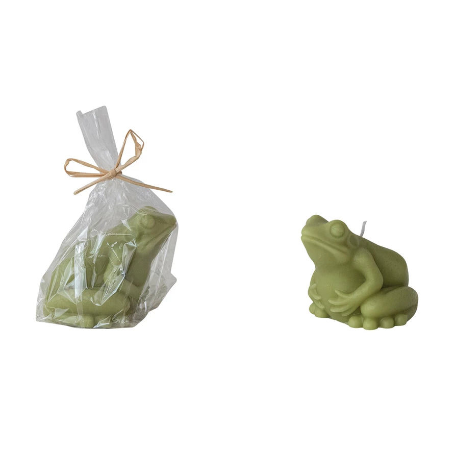 Green frog-shaped candle with a clear bag containing more candles on a white background