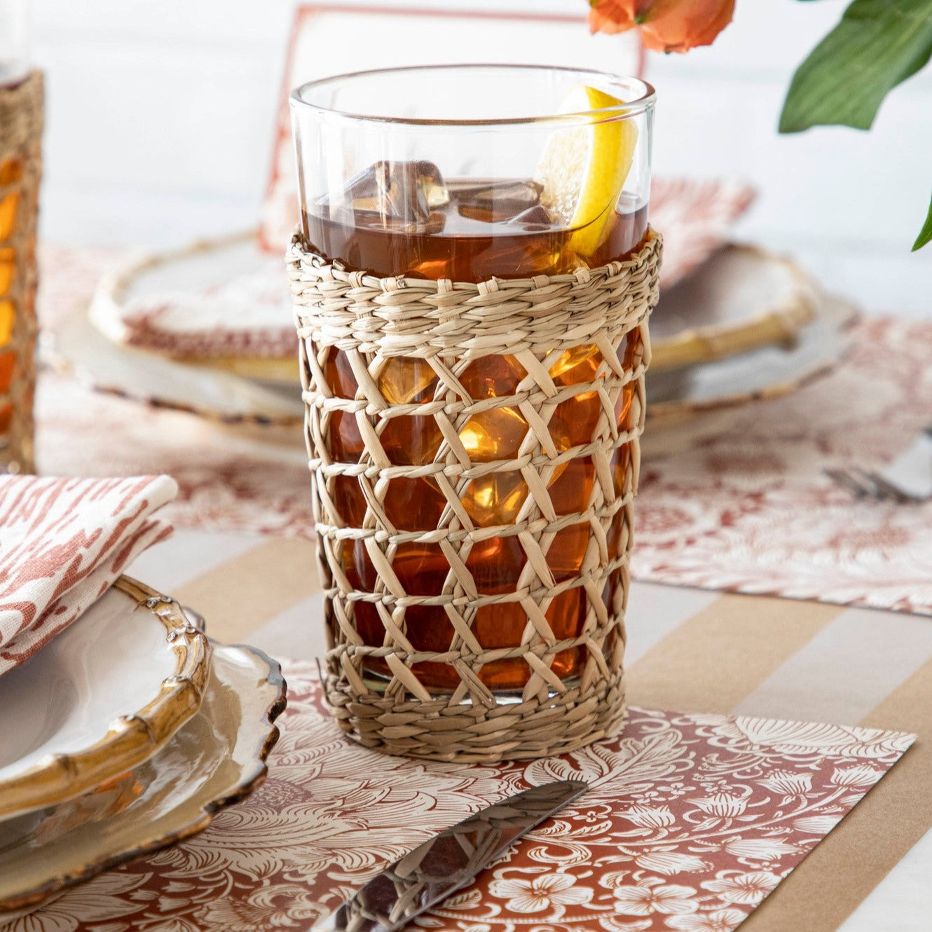 Iced tea with lemon in a Seagrass Cage Highball Glass with a Kiss That Frog wrapping on a table set for a meal.
