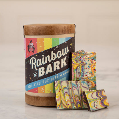Gluten-free Hester &amp; Cook rainbow bark made with Belgian chocolate displayed in a tin on a counter.