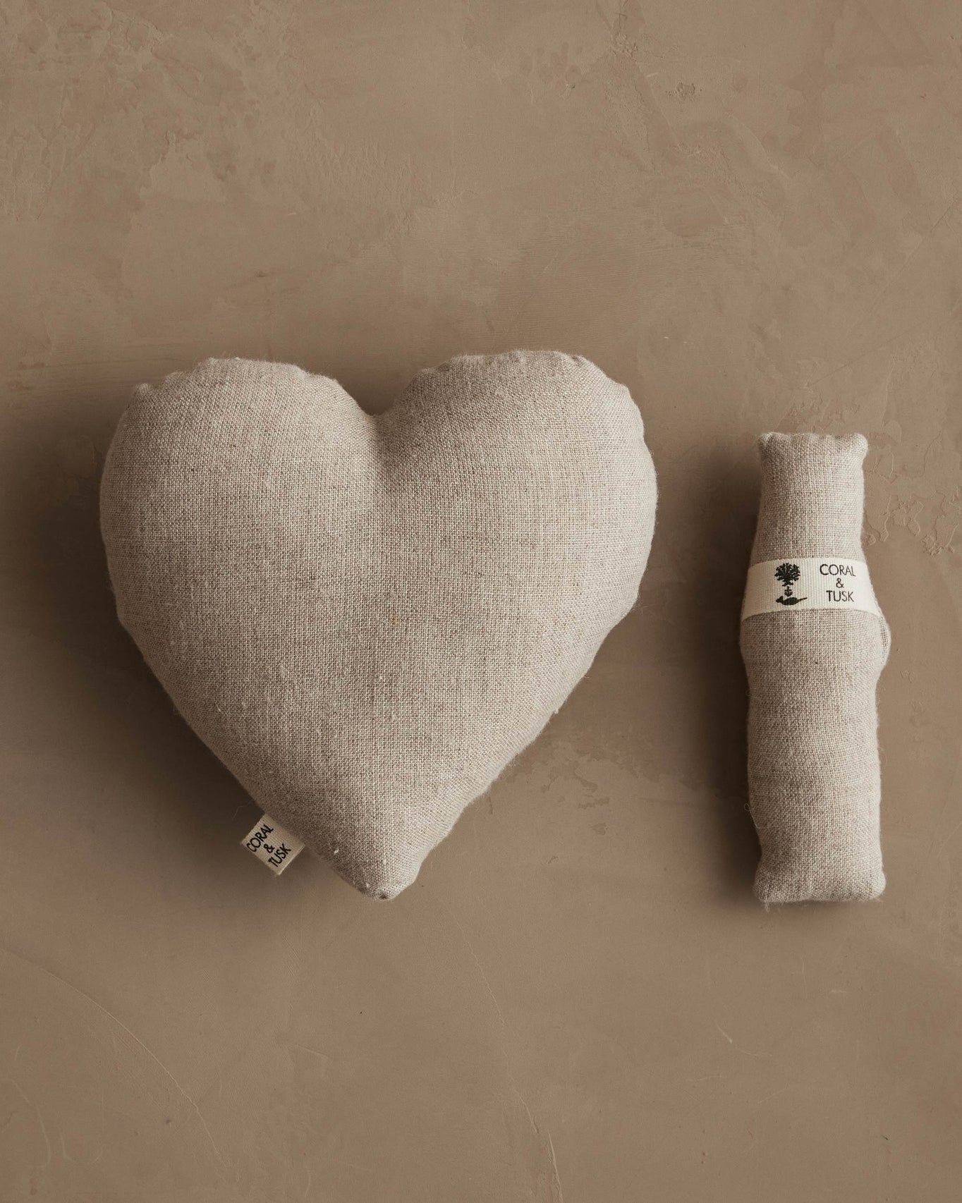 Heart-shaped pillow and small fox plush on a beige background.