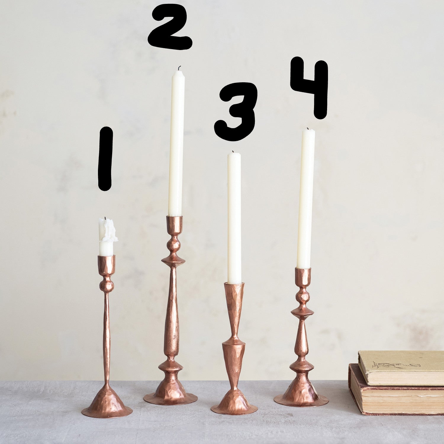Copper Hand-Forged Cast Iron Taper Candle Holder in 4 styles with white candles in them.