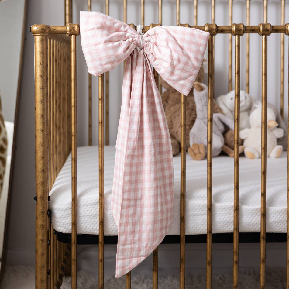 Gold crib with pink checkered bow and stuffed toys