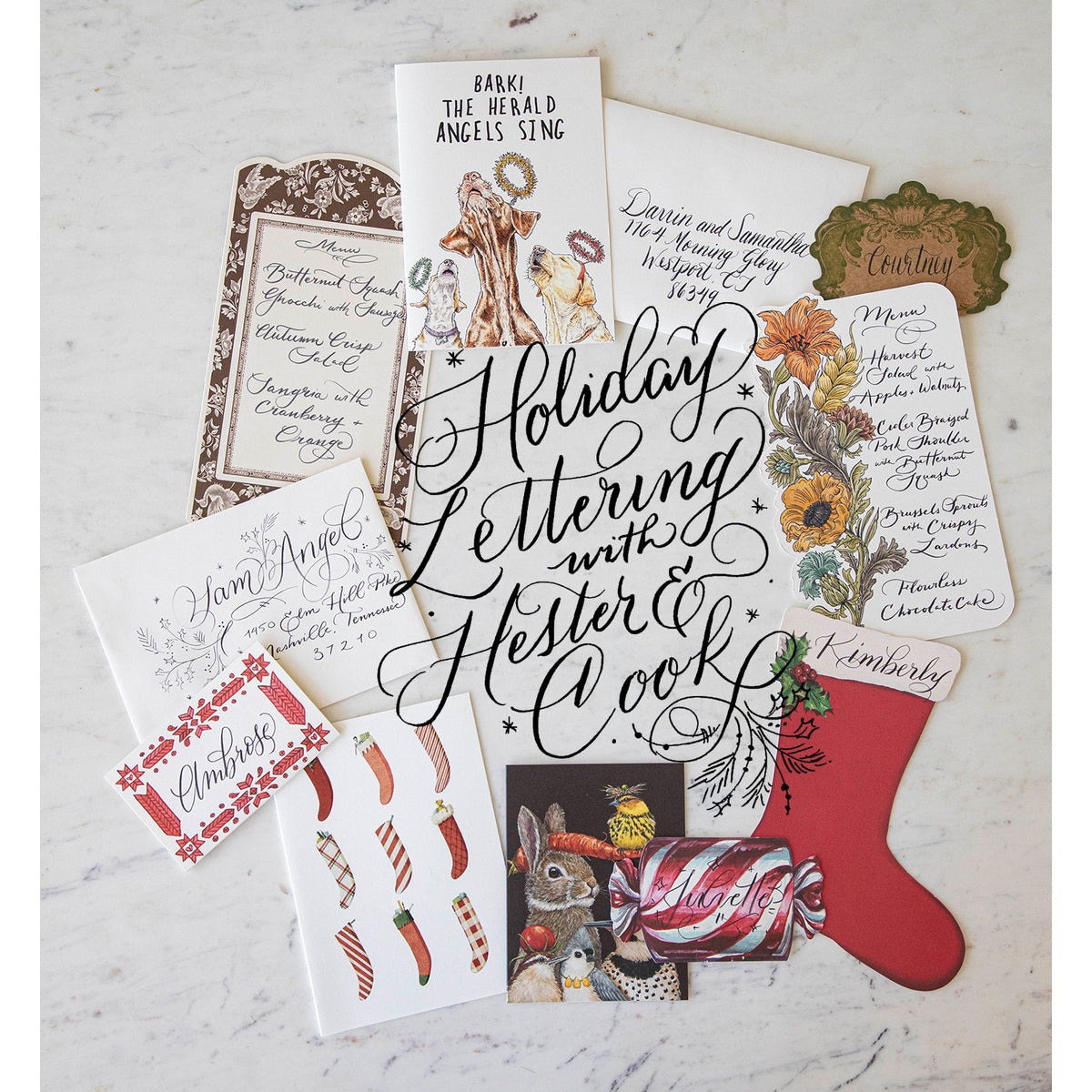 An assortment of hand lettered cards, envelopes, menu cards and more with elegant lettering in the middle saying "Holiday Lettering with Hester & Cook".