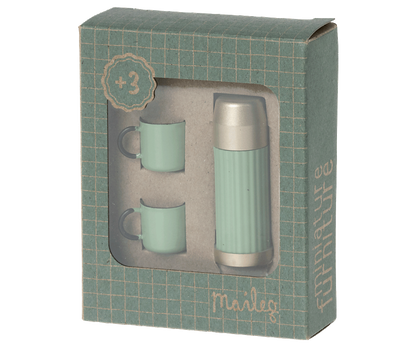 A Mini Thermos and Cups Set from Maileg, with two cups and a teapot in a green box. The cups are perfectly sized for sipping your favorite blend, and the teapot allows for easy pouring. This set