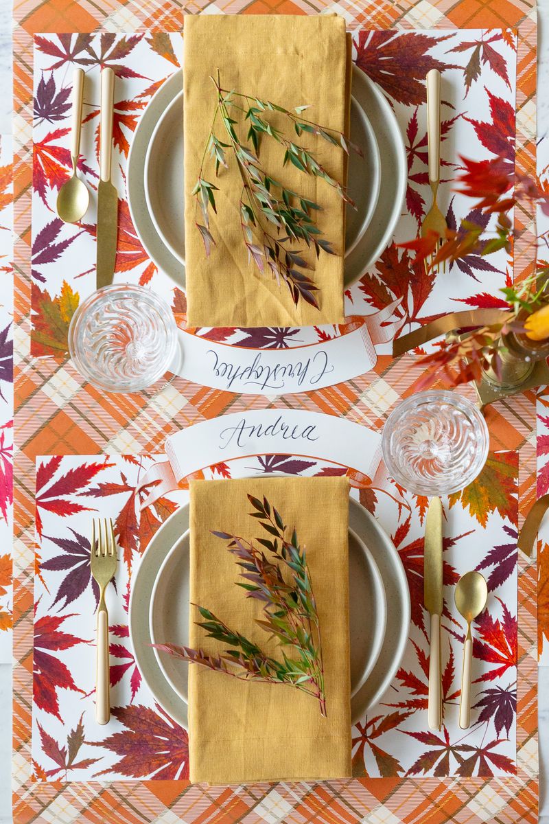 A top-down view of a table setting for two featuring the Maple Leaves Placemat by Hester & Cook.