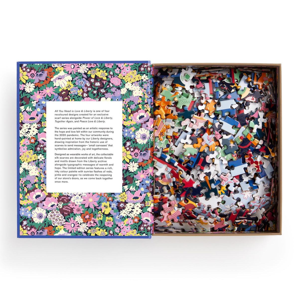 A jigsaw puzzle designed to look like a keepsake box with magnetic closure, titled "Liberty All You Need is Love Puzzle" featuring a colorful, Thorpe print design. It consists of the Liberty All You Need is Love 500 Piece Book Puzzle by Chronicle Books.