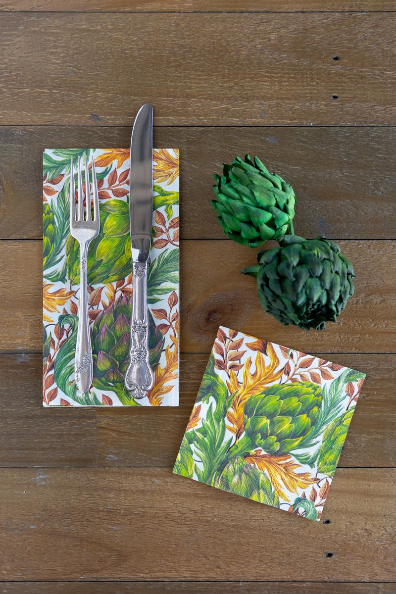 Two napkins on a wooden surface, one cocktail sized and one guest sized, both with a vibrant artichoke design.