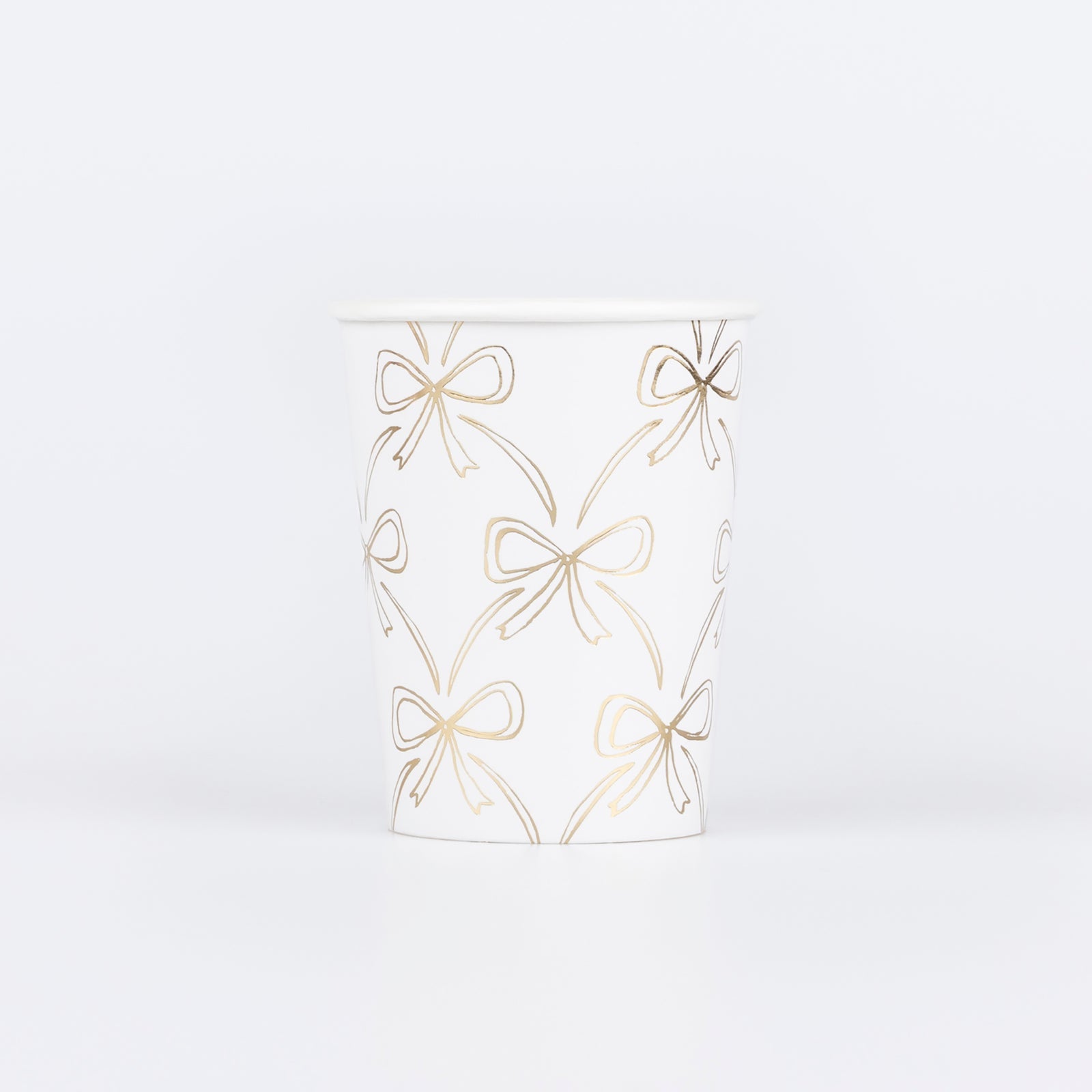 Paper cup by Meri Meri with illustrations of gold bows.