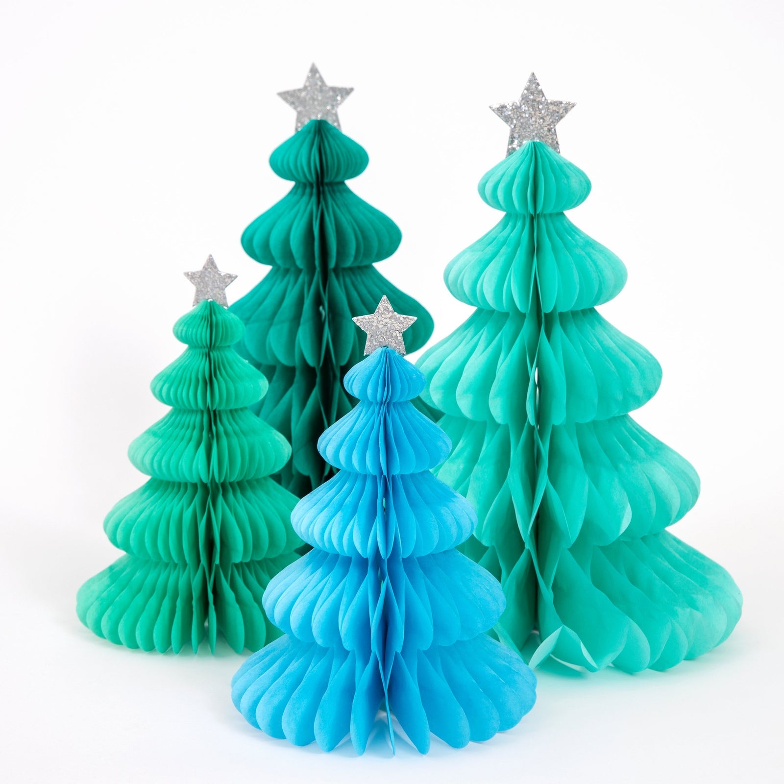 Set of four paper Christmas trees in green, blue, and teal with silver stars on a white background.