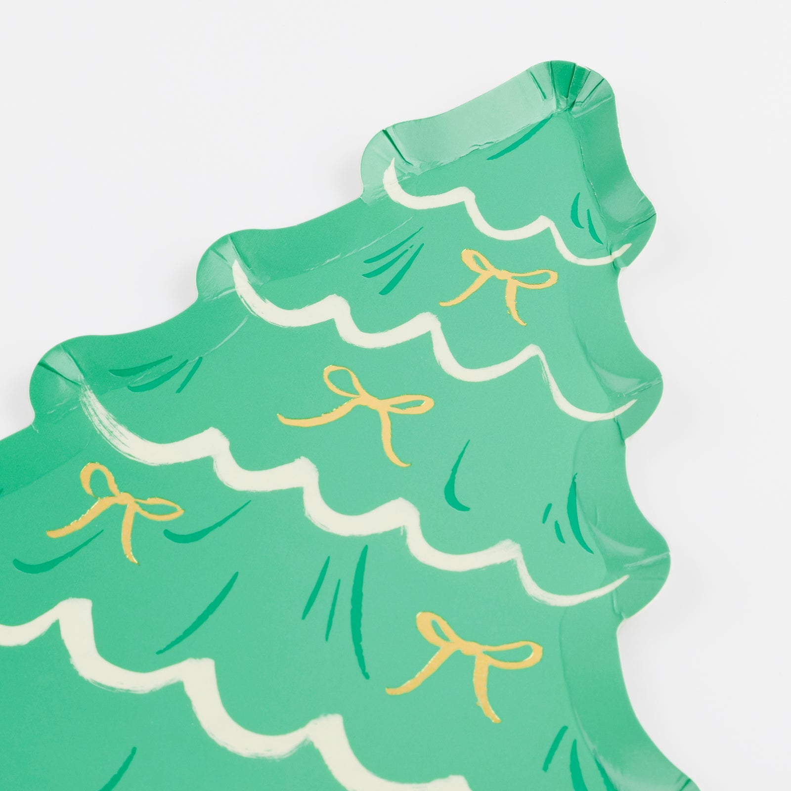 Green paper plate shaped like a Christmas tree with gold ribbons on a white background.
