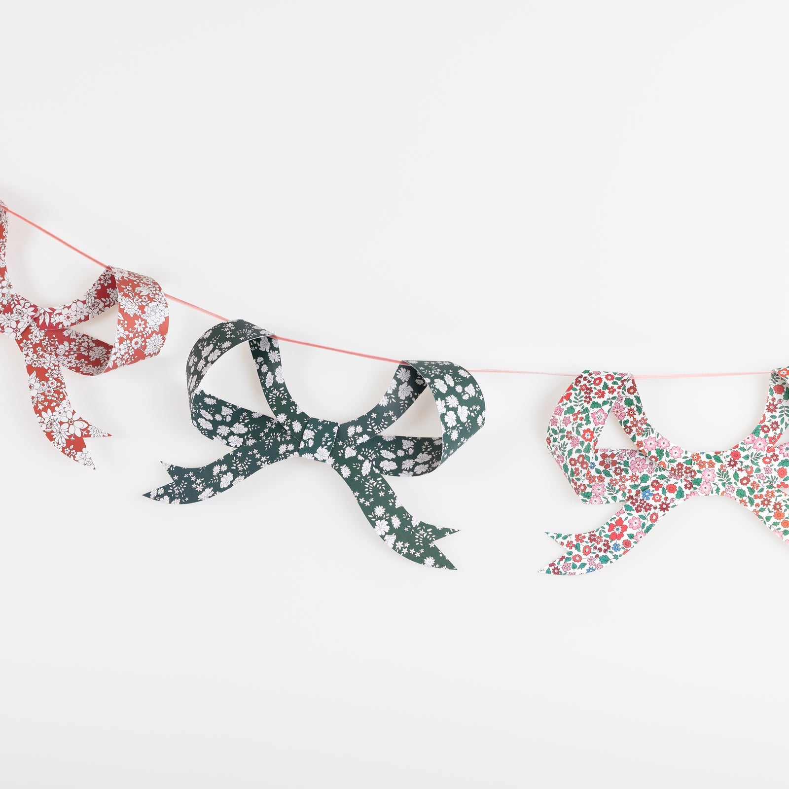 Decorative garland with Liberty of London printed bows on a white background.
