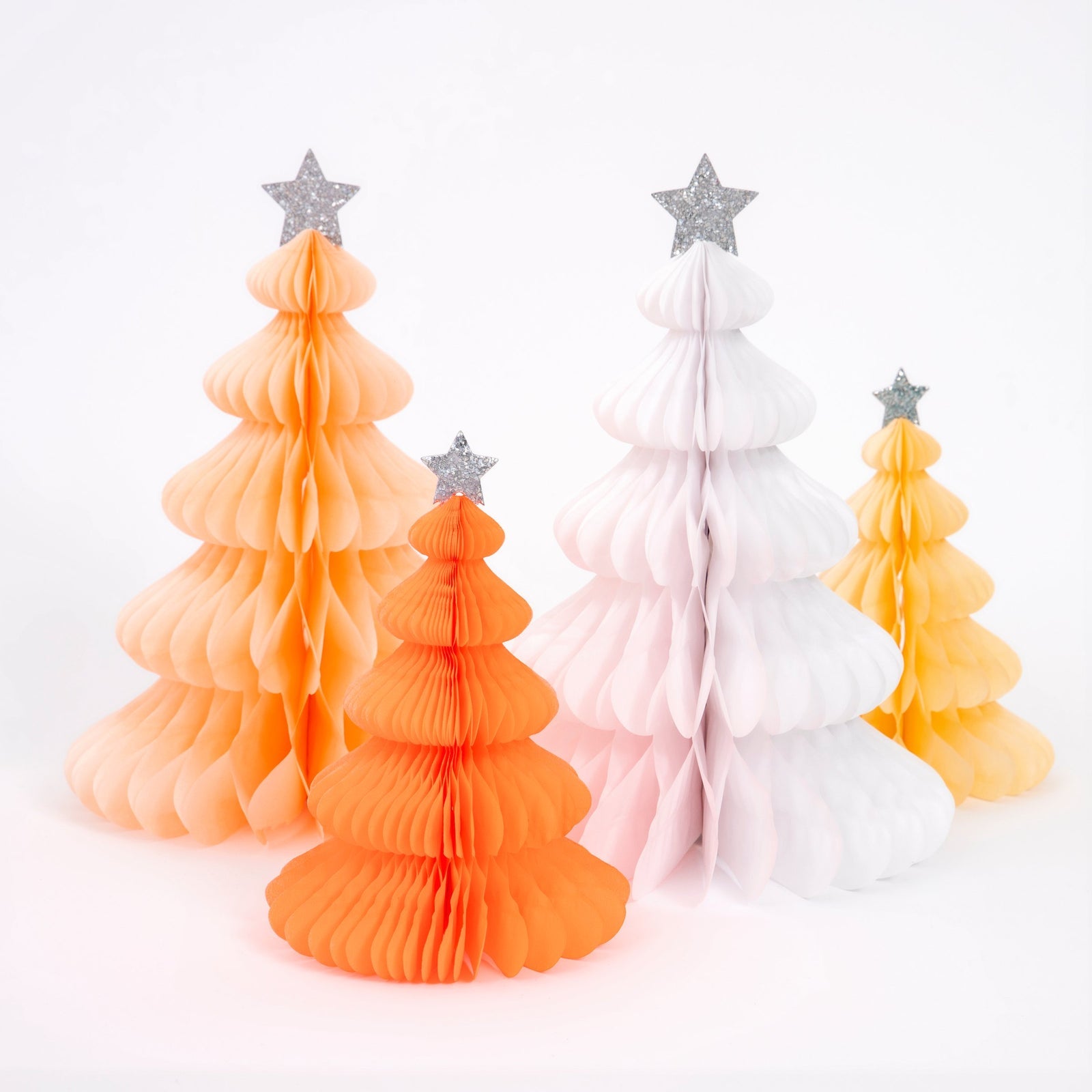 Set of four decorative paper Christmas trees in orange, pink, and white with star toppers on a white background.