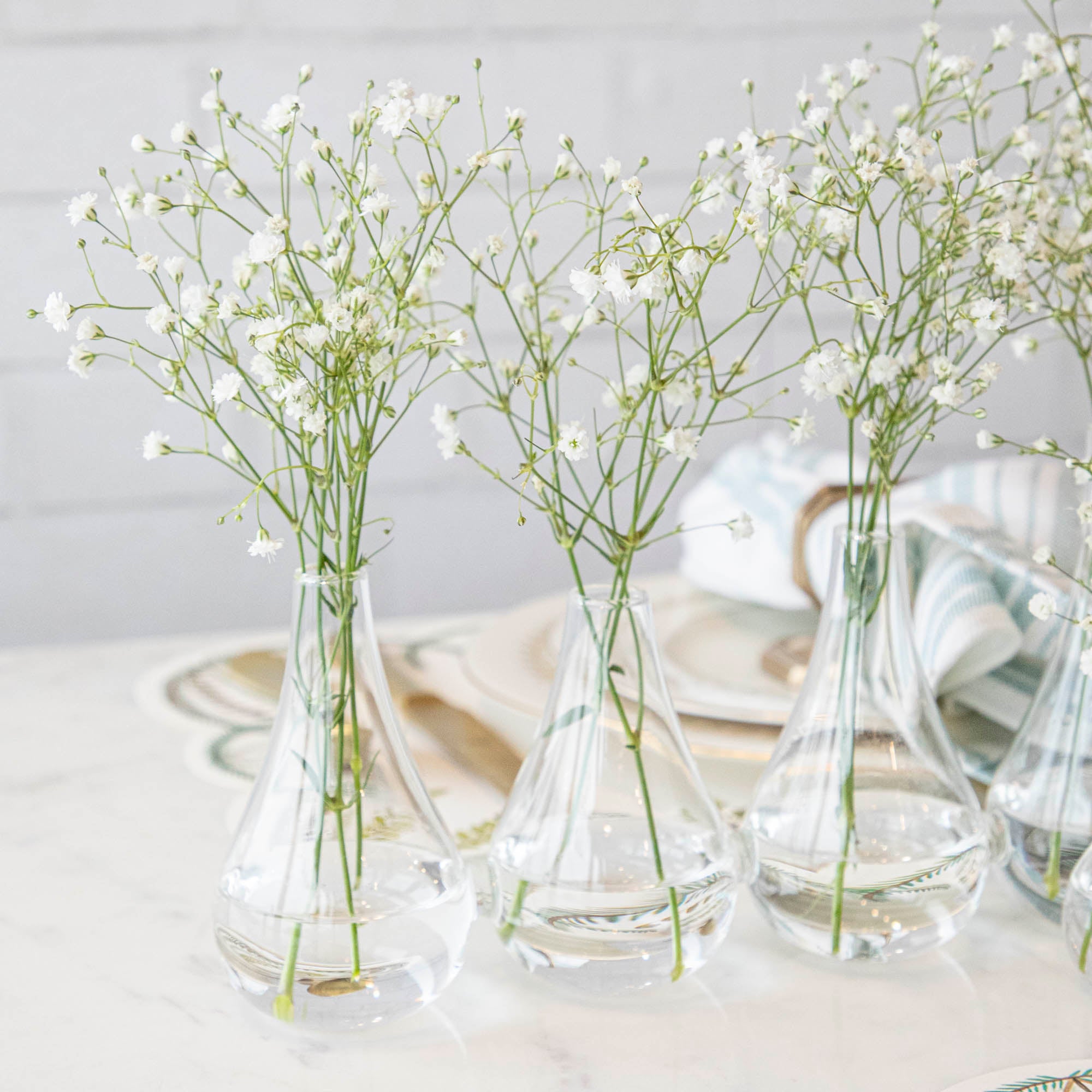 Five Quintet Glass Vases of varying shapes holding floral cuttings of pink roses and baby&