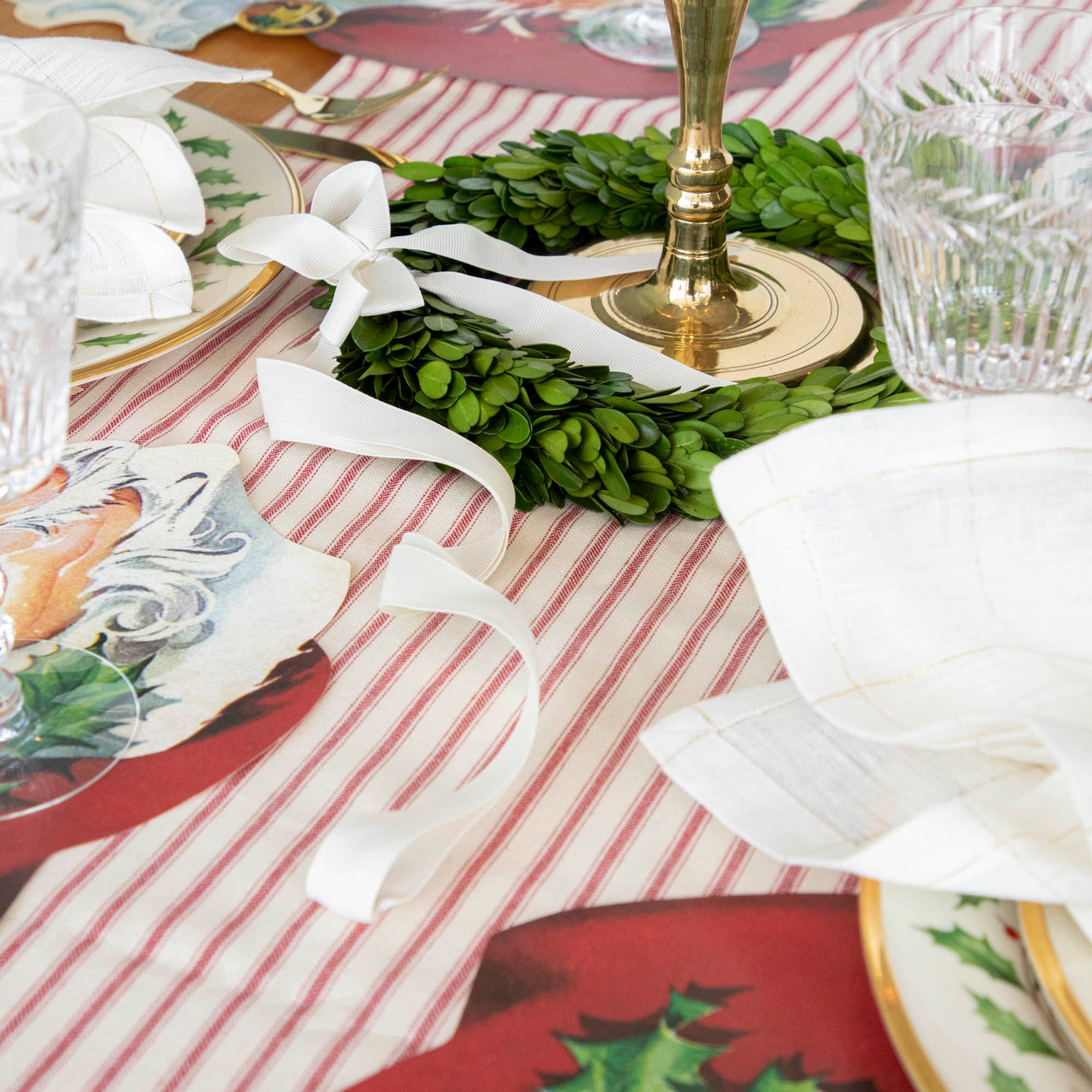 A beautiful Christmas table setting adorned with fresh Porch View Home boxwood wreaths with Cream Grosgrain Ribbon and botanical preserved napkins.