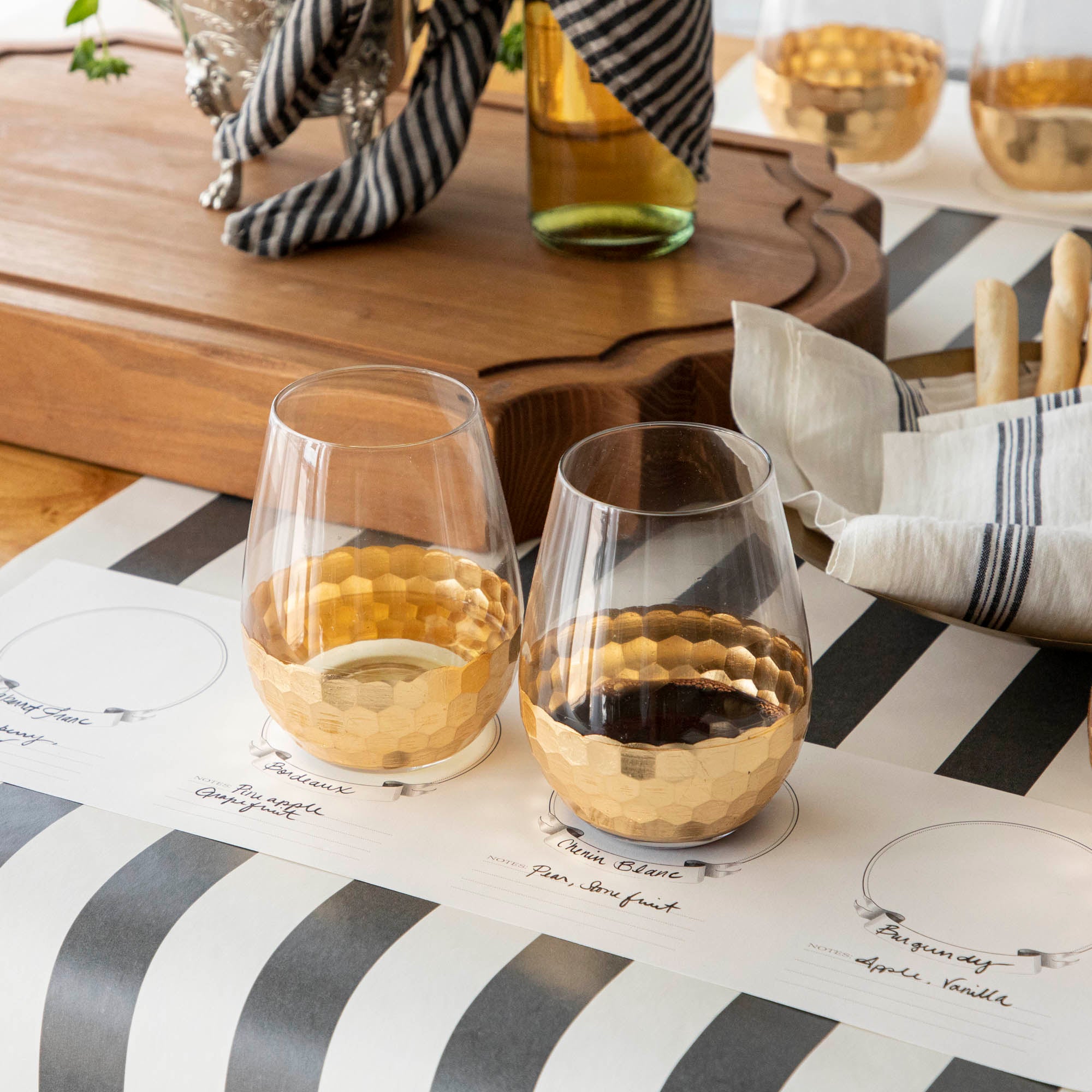 A table setting with Vitorrio Stemless Glassware plates, and napkins.