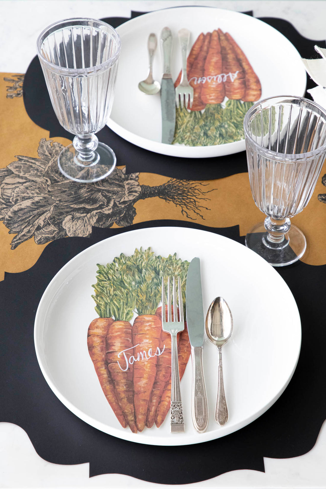 A rustic table setting featuring Carrots Table Accents resting on each plate with names written on them in white ink.