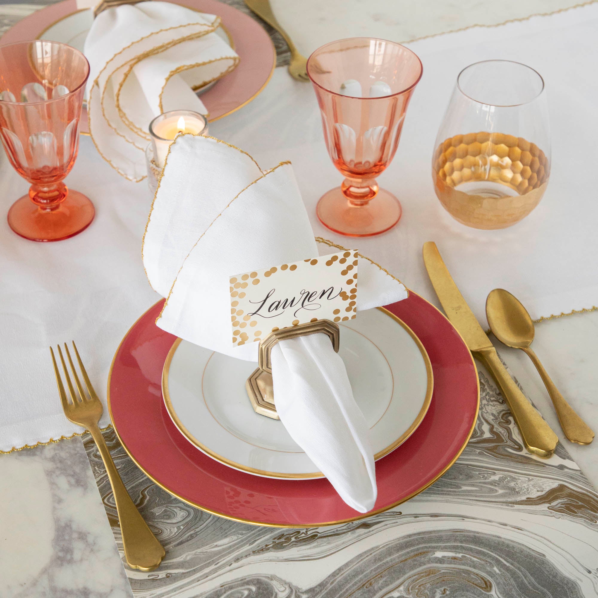 A table setting with Vitorrio Stemless Glassware plates, and napkins.