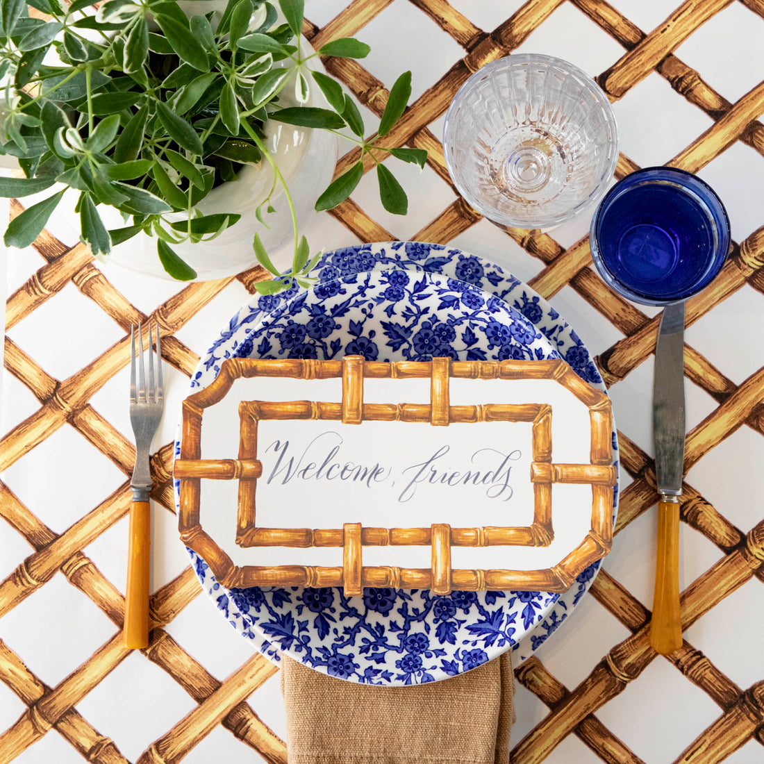 A Burleigh Blue Arden dinnerware plate on a wicker placemat with a folded napkin and a fork to the side, also noted as dishwasher safe.