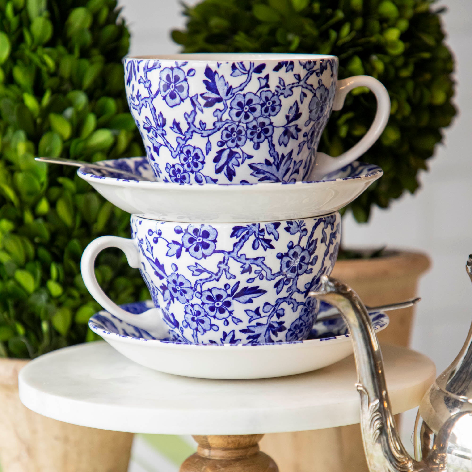 A Burleigh Blue Arden dinnerware plate on a wicker placemat with a folded napkin and a fork to the side, also noted as dishwasher safe.