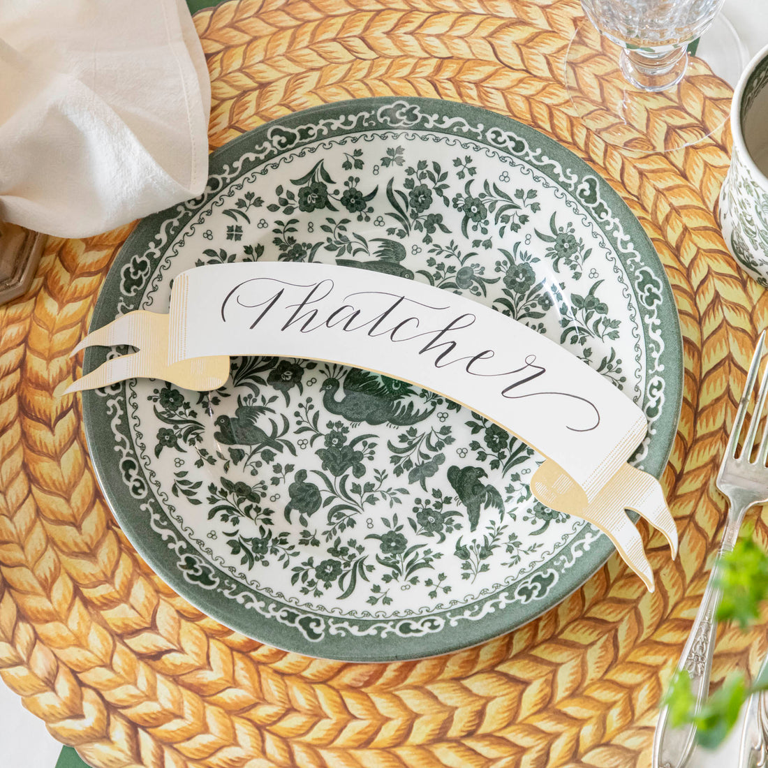 A table setting with a green and white place setting that features Burleigh&