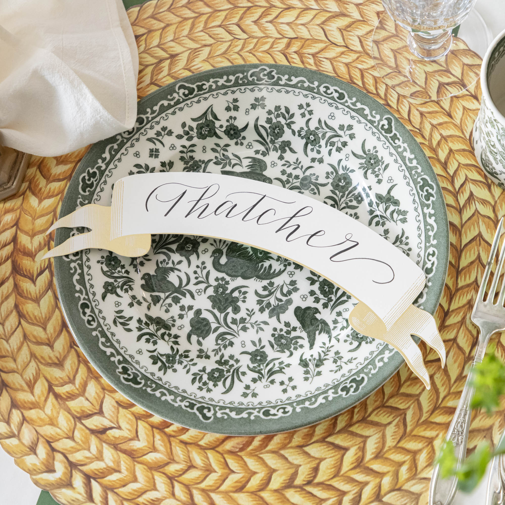A table setting with a green and white place setting that features Burleigh&