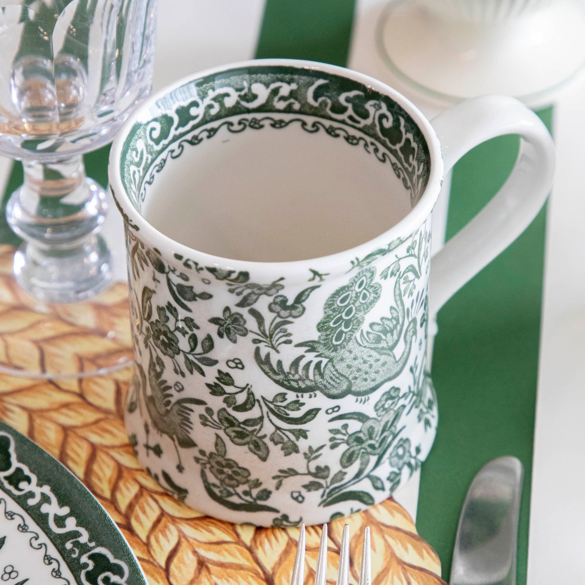 A table setting with a green and white place setting that features Burleigh&