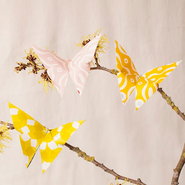 Origami Cloud of Butterflies Kit with instructions and Cambridge Imprint patterned paper on a wooden table.