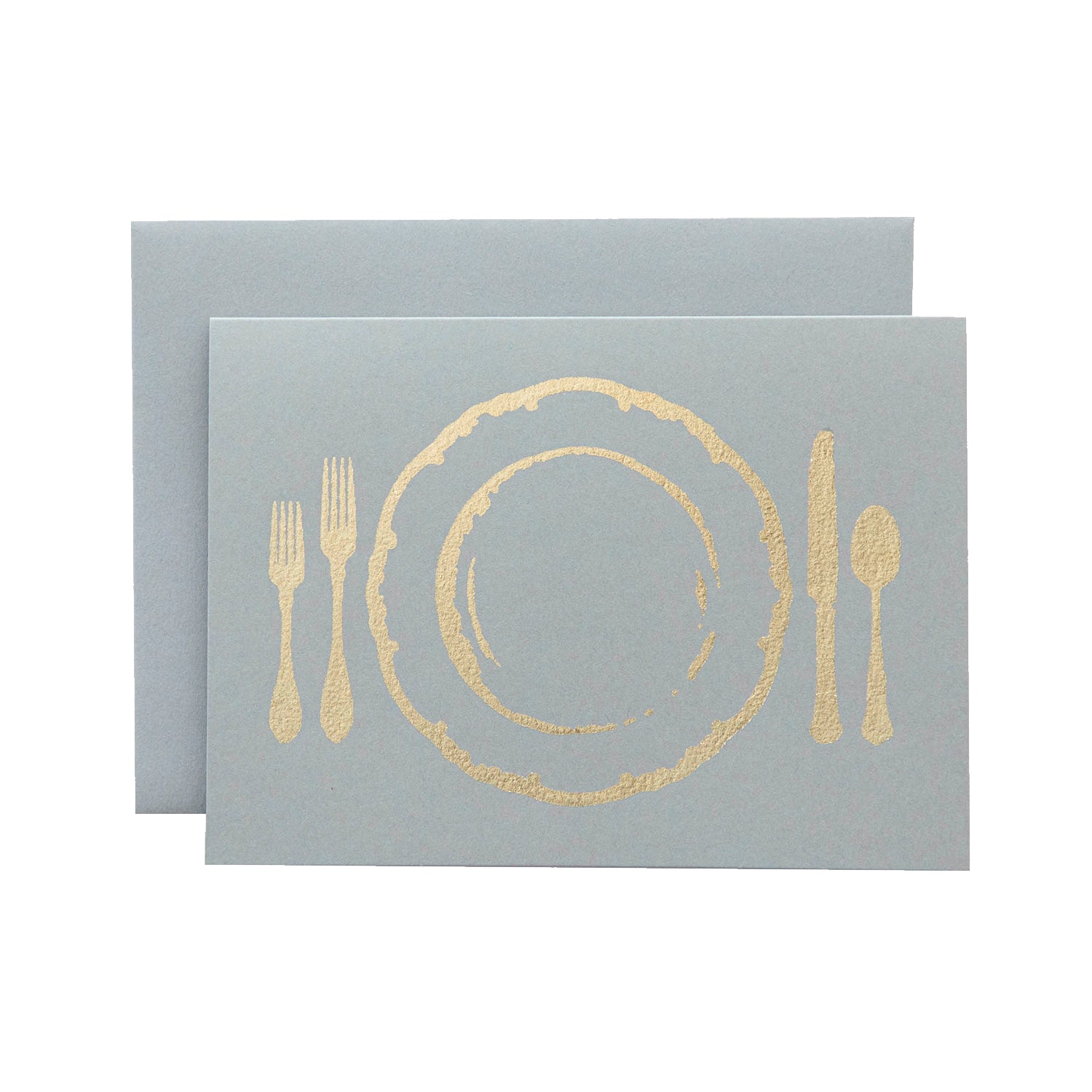 A light gray card with the silhouette of a place setting including a plate and cutlery in solid gold leaf.