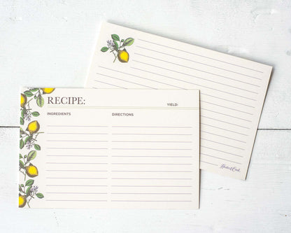 Both sides of a lined recipe card with space for ingredients and directions on the front, with more lined space on the back. The front of the card is adorned with yellow lemons and green leaves with white blossoms along the left edge, and the back features one lemon in the upper left corner.