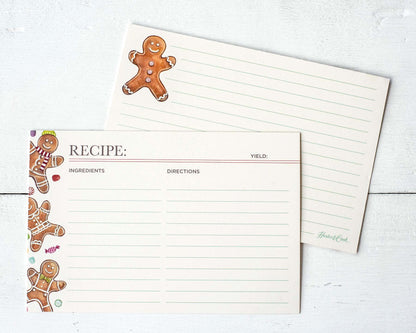 Both sides of a lined recipe card with space for ingredients and directions on the front, with more lined space on the back. The front of the card is adorned with three gingerbread men and colorful holiday candies along the left side, and the back features one gingerbread man in the upper left corner.