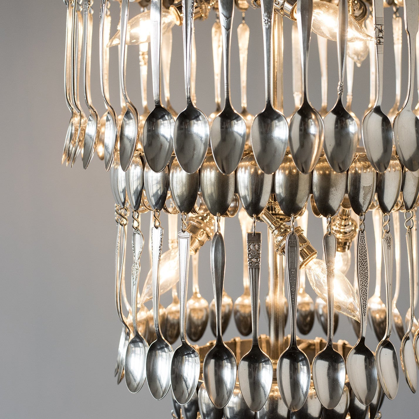 A handcrafted Triple Tier Spoondelier made by Hester & Cook hanging from a chain.