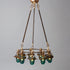Antique bronze chandelier with multiple glass lampshades and antique insulators suspended from the ceiling, made in the USA by Hester & Cook&