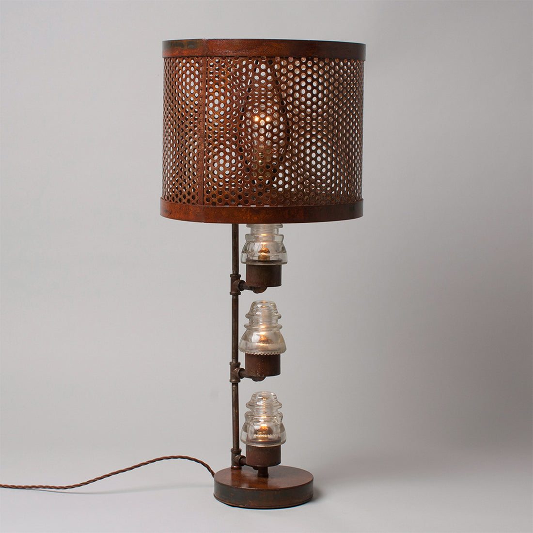 A traditional Hester &amp; Cook Telegraph Table Top Lamp with a metal shade and a basket on top.