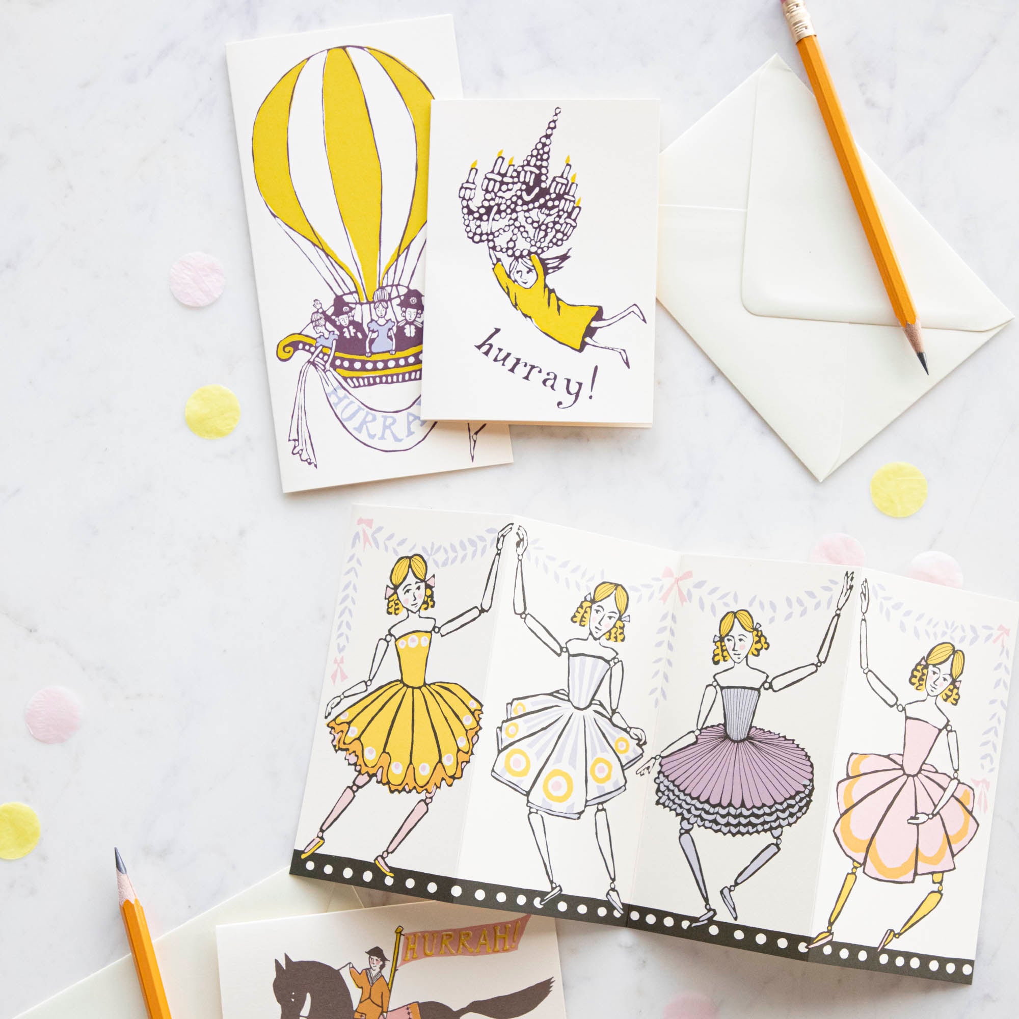 An assortment of cards by Cambridge Imprints on a white background with pencils.