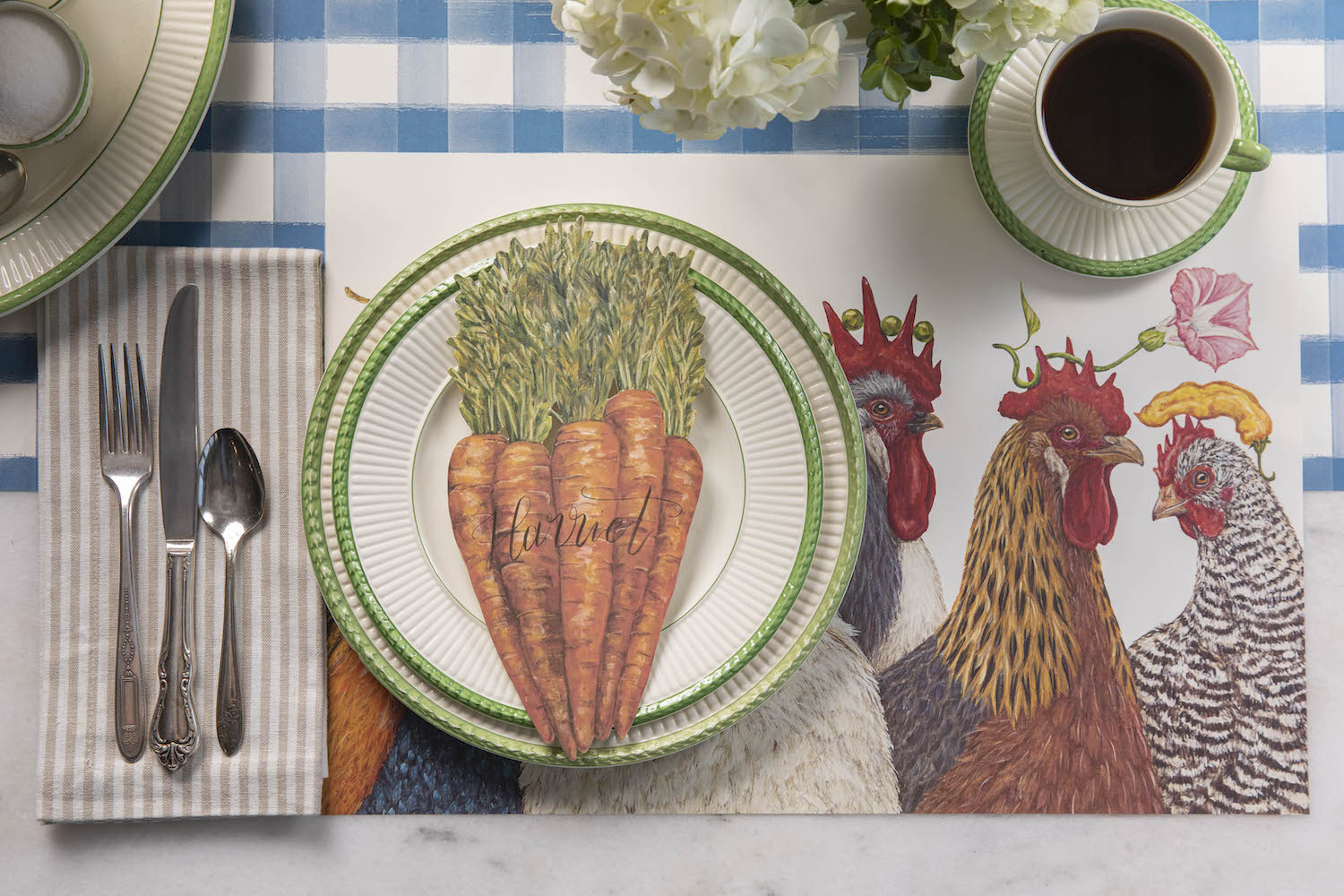 The Chicken Social Placemat under a charming place setting with a cup of coffee.