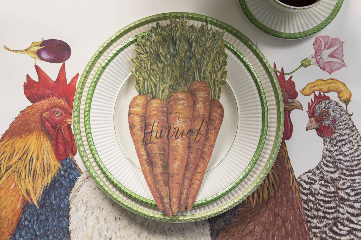 A Carrots Table Accent labeled &quot;Harriet&quot; resting on the plate of a rustic place setting, from above.