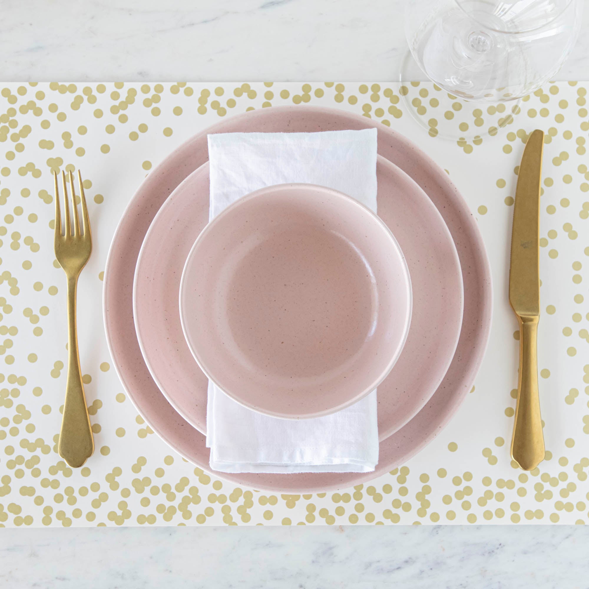 Pink and gold placemat from the Pacifica Marshmallow Dinnerware collection by Casafina Living.