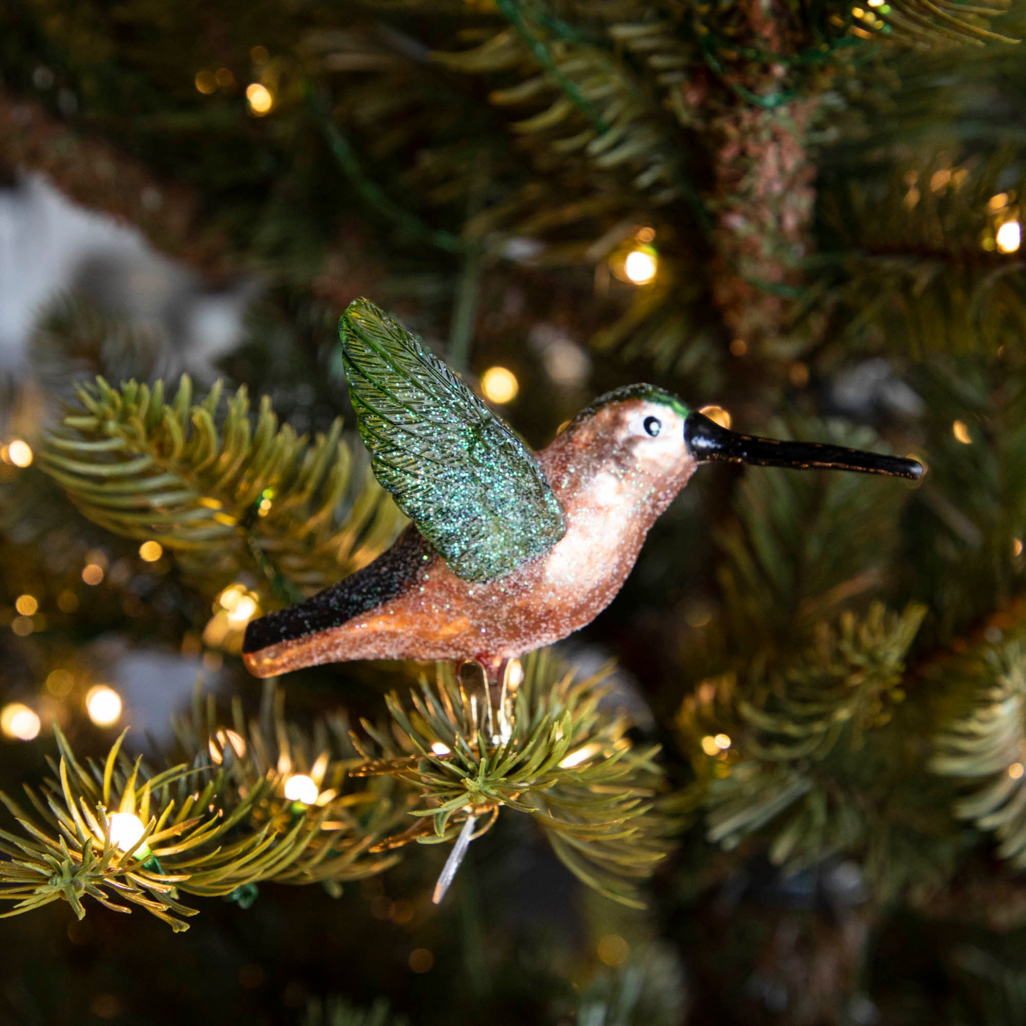 Glass Hummingbird Ornament clipped into a tree.