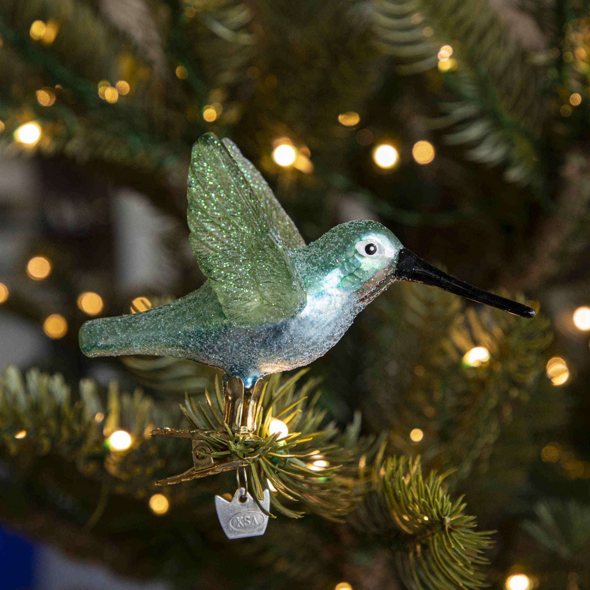 Glass Hummingbird Ornament clipped into a tree.