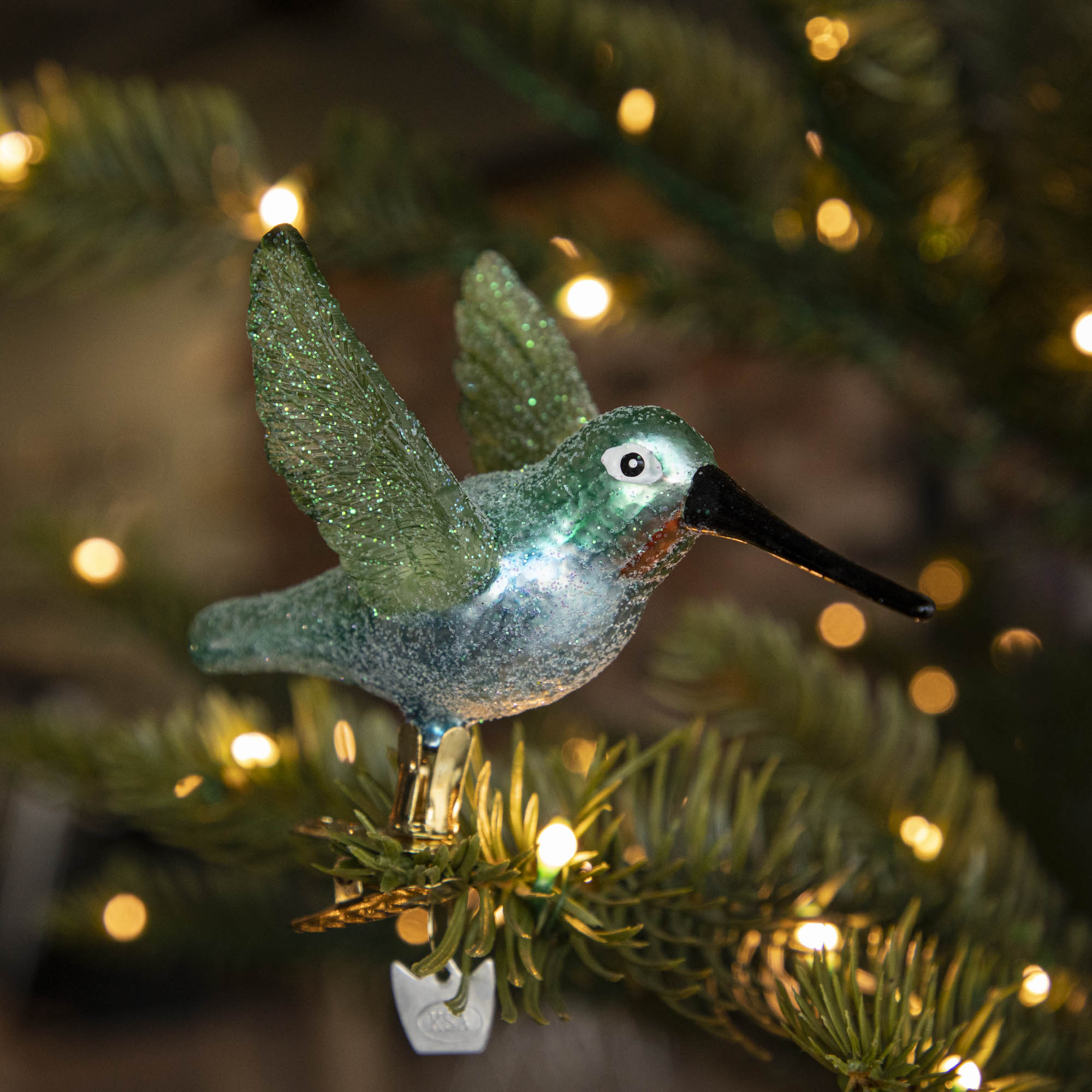Glass Hummingbird Ornament clipped into a tree.