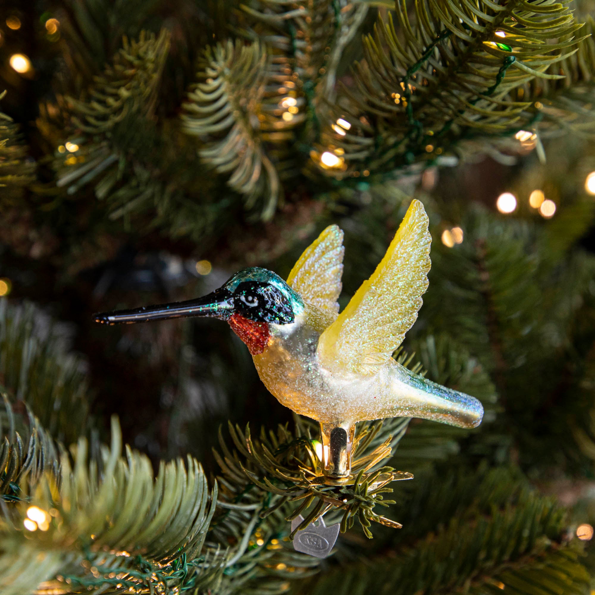 Glass Hummingbird Ornament clipped into a tree.