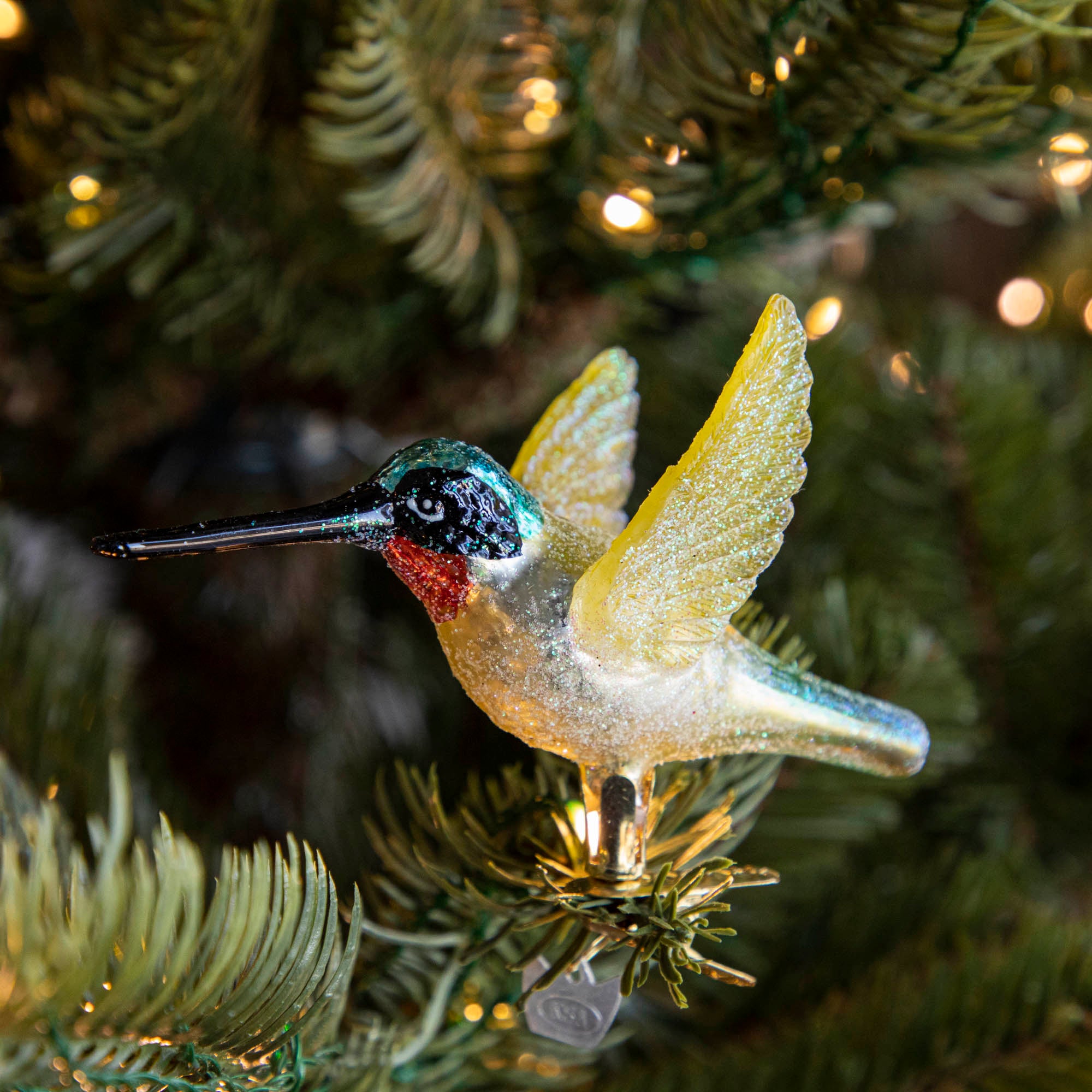 Glass Hummingbird Ornament clipped into a tree.
