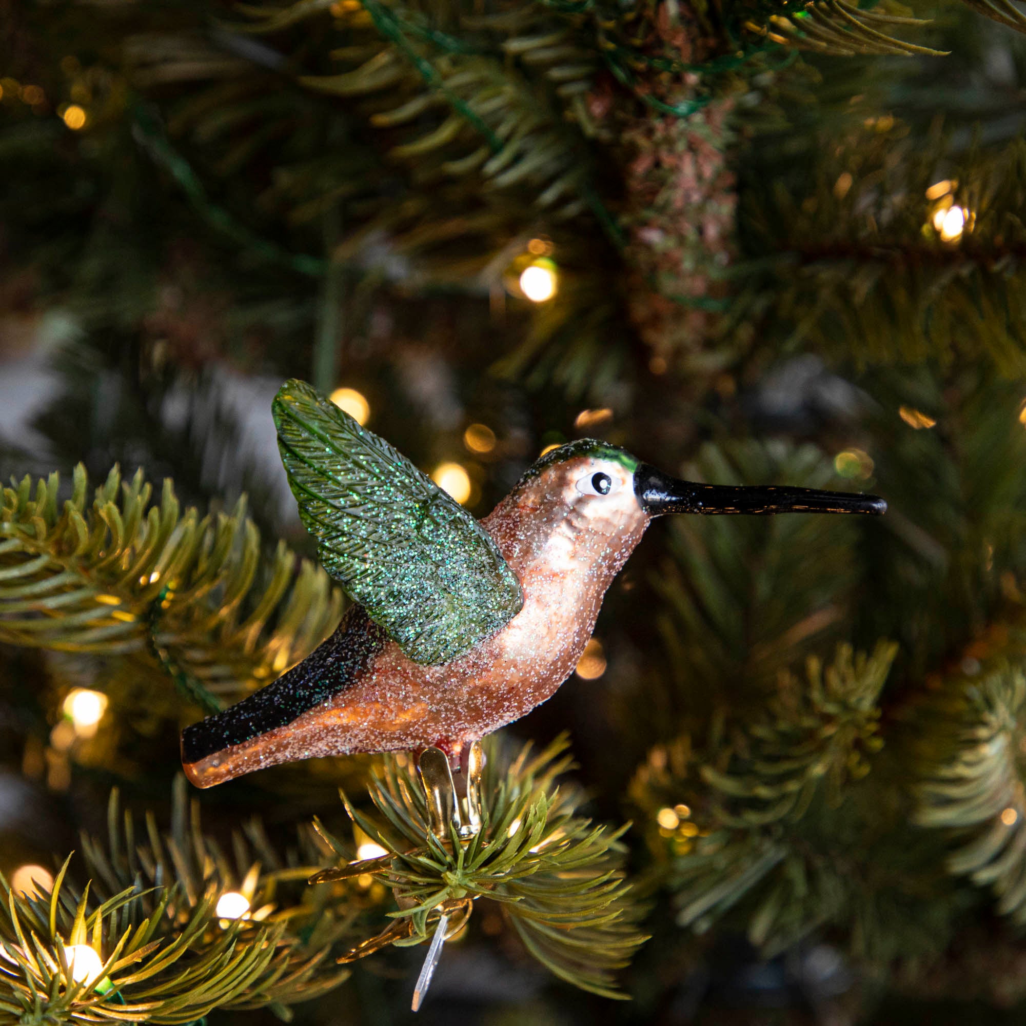 Glass Hummingbird Ornament clipped into a tree.