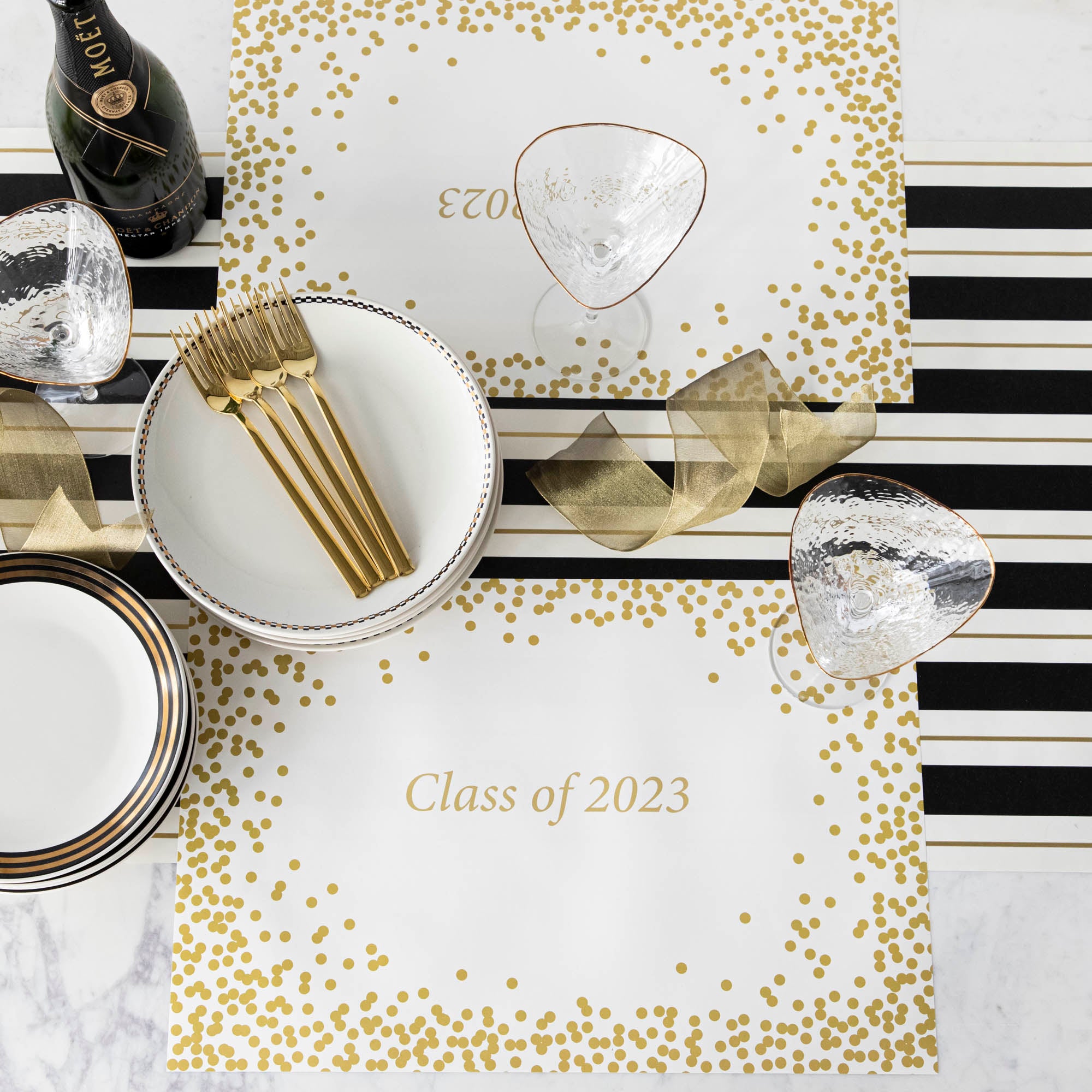 Table setting with Gold Confetti Placemat with personalized message printed in gold color: "Class of 2023".