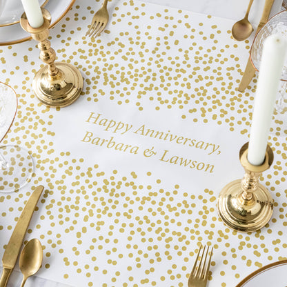 The Gold Confetti Personalized Runner under an elegant table setting, with &quot;Happy Anniversary, Barbara &amp; Lawson&quot; printed in gold in the center.