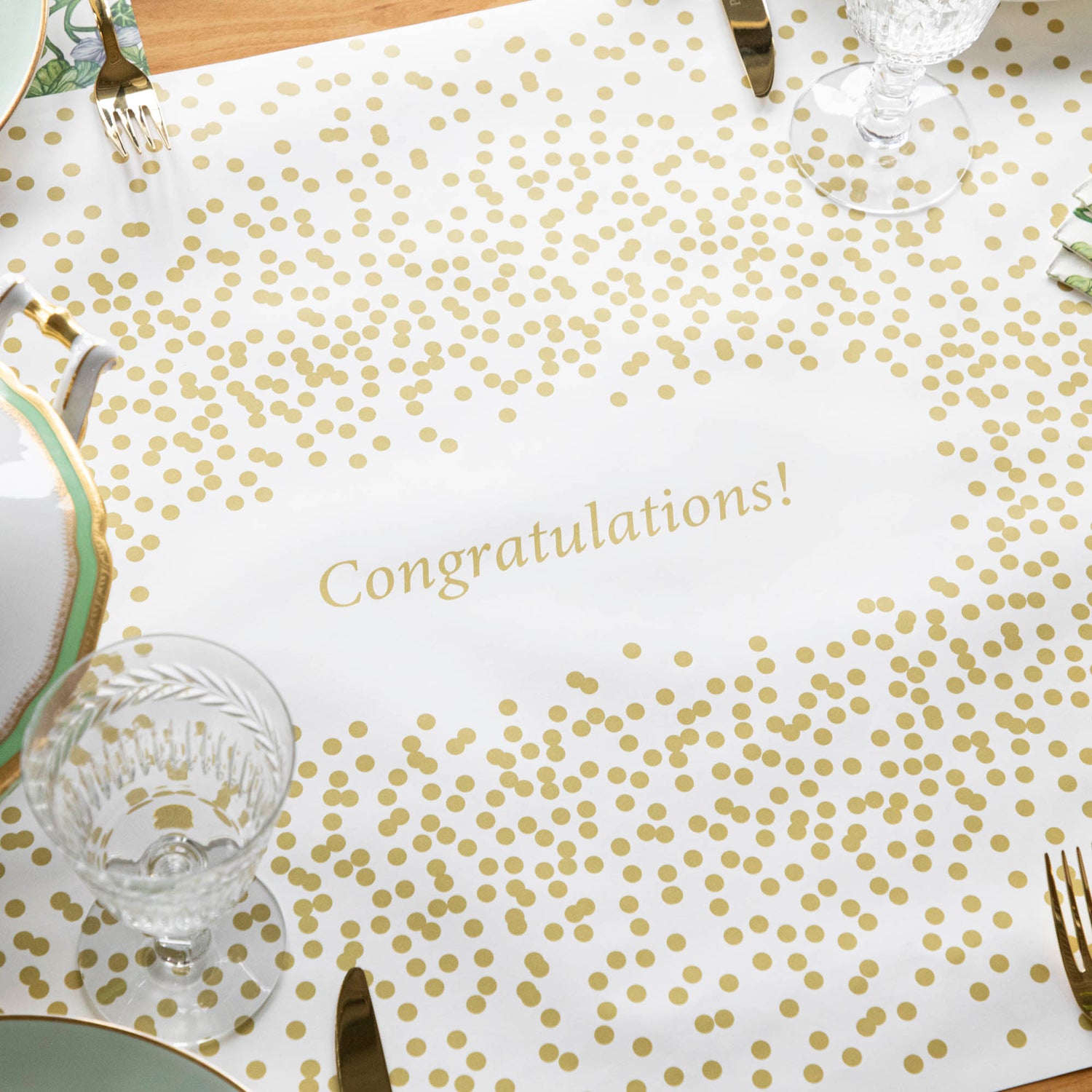 A white paper runner with gold confetti dots scattered around the perimeter, with an open area in the middle for a personalized message.